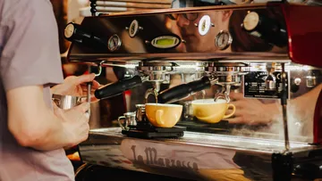 Barista bereitet Kaffee mit Espressomaschine zu.
