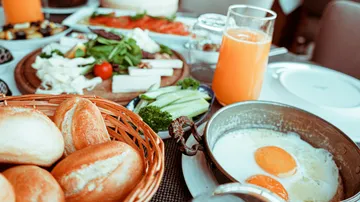 Frühstück mit Eiern, Brot und Orangensaft.