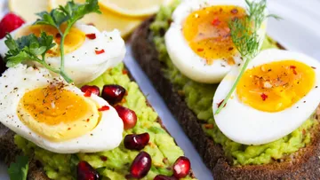 Avocado toast with eggs and pomegranate seeds.
