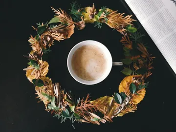 Kaffeetasse in einem Kranz aus getrockneten Blättern.