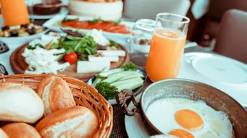 Breakfast table with eggs and orange juice.