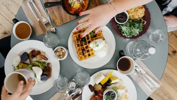 Frühstückstisch mit Kaffee und Waffeln gedeckt.