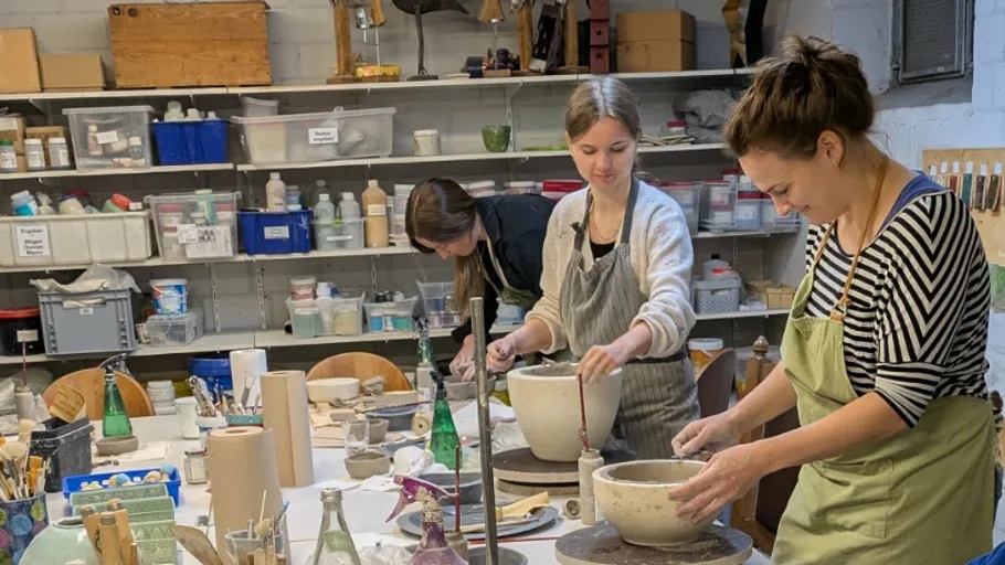 People crafting pottery in a studio setting.