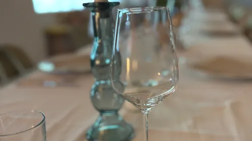 Nahaufnahme eines Weinglases auf gedecktem Tisch.