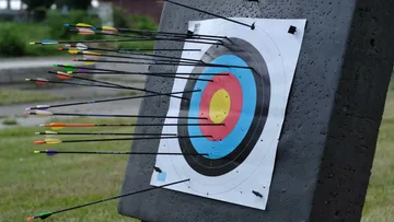 Archery target with multiple arrows outdoors.