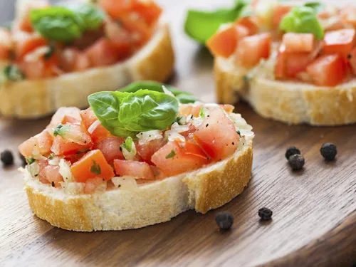Tomatenbruschetta auf Brot, serviert auf einem Holzbrett.