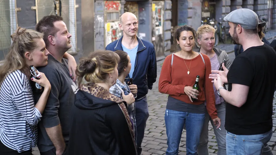 People gathered outside, listening to a man.