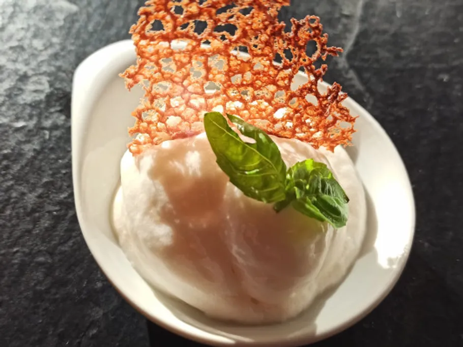 Ice cream in bowl with crispy cookie and mint.