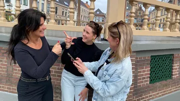 Drei Frauen unterhalten sich auf einer Brücke.