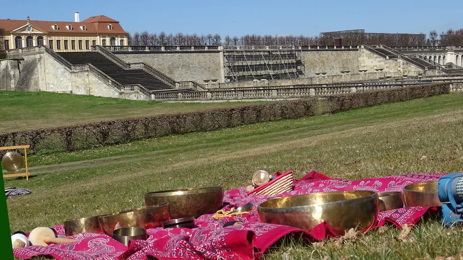Tibetan bowls on a red cloth, historic building background.