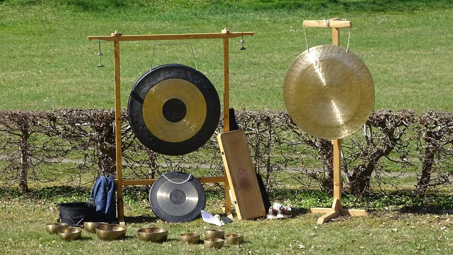 Gongs and bowls set up outdoors.