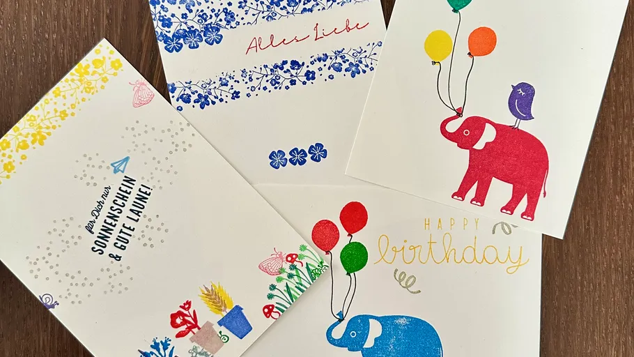 Colorful greeting cards arranged on wooden table.