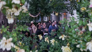 Menschen im Freien von Blumen umgeben.