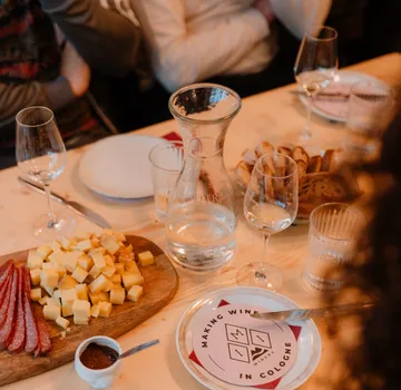 Cheese and salami on table with glasses.