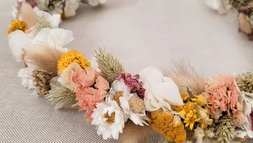 Blumenkranz mit getrockneten Blumen auf Stoff.