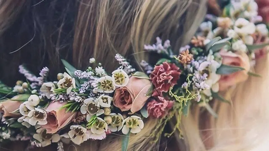 Floral crown on blonde hair outdoors.
