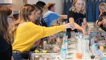 Group making drinks together at a bar.