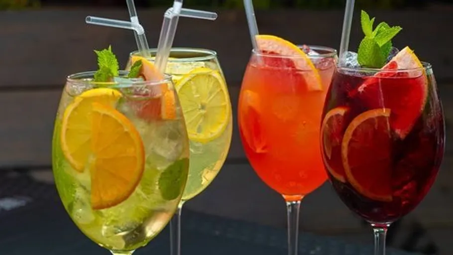 Colorful cocktails with fruit and mint outdoors.