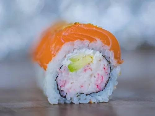 Sushirolle mit Lachs, gefüllt mit Reis und Gemüse.