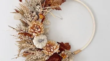 Floral autumn wreath with dried flowers, white background.