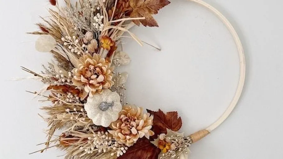 Floral autumn wreath with dried flowers, white background.