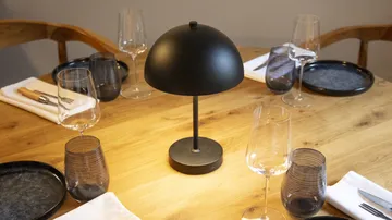 Tischgedeck mit Gläsern und Lampe.