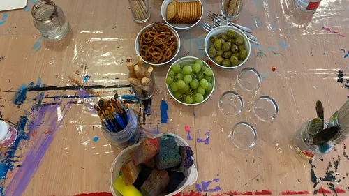 Art supplies and snacks on a painted table.