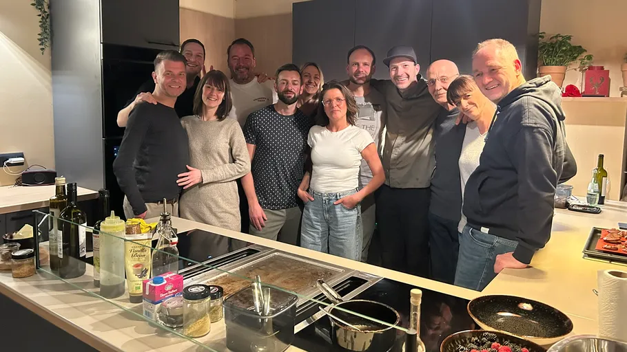 Group smiling in modern kitchen gathering.