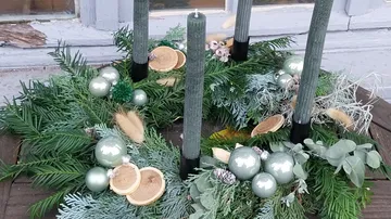 Advent wreath with green candles and ornaments.