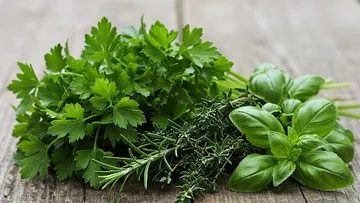 Fresh herbs on rustic wooden surface.