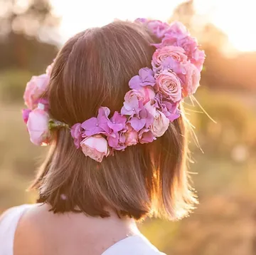 Woman with flower crown in sunlight field.