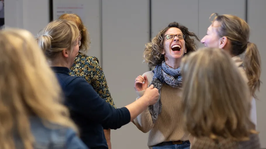 Group of women laughing in a room.