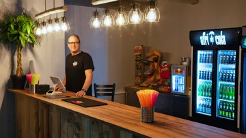 Mann hinter Holztresen in Snackbar.