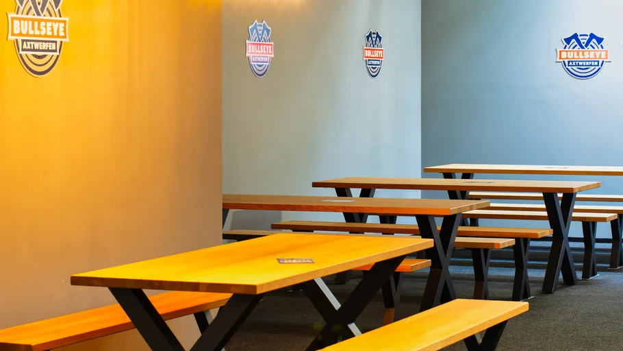Wooden benches in a room with wall logos.