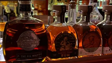 Whiskey- und Rumflaschen an einer Bar.