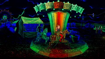 Child riding carousel horse at night fair.