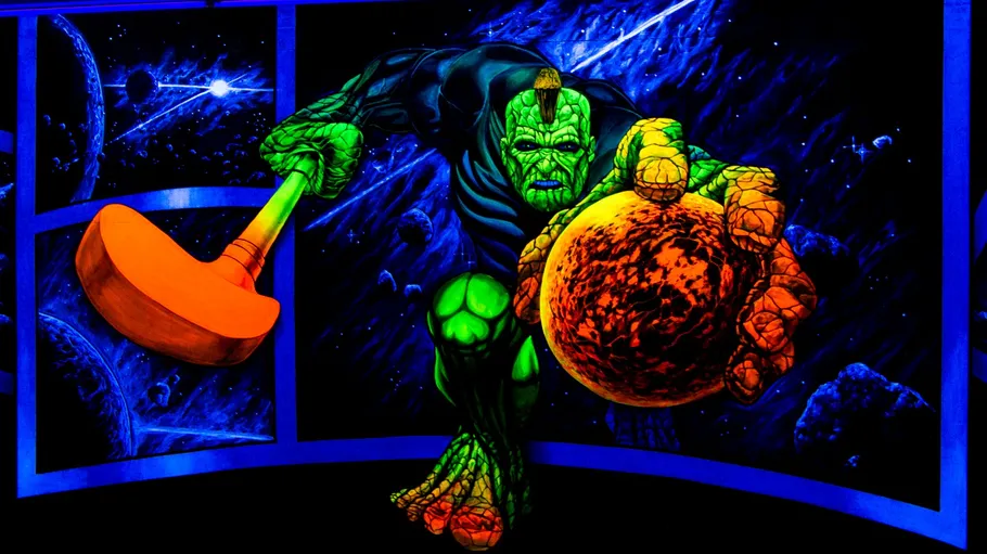 Green superhero with hammer in space scene.