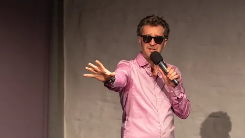 Person with microphone giving a speech indoors.