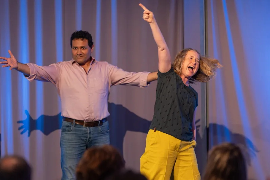 Two people performing enthusiastically on stage.