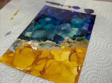 Abstract alcohol ink art on white paper towel.