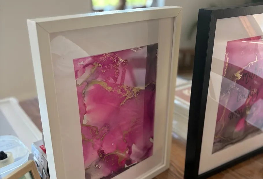 Framed abstract art on a wooden table.