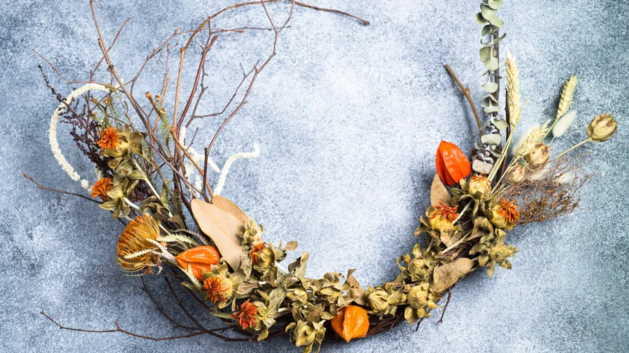 Wreath made of dried flowers on concrete surface.