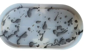 Gray silicone mold with abstract shapes inside.