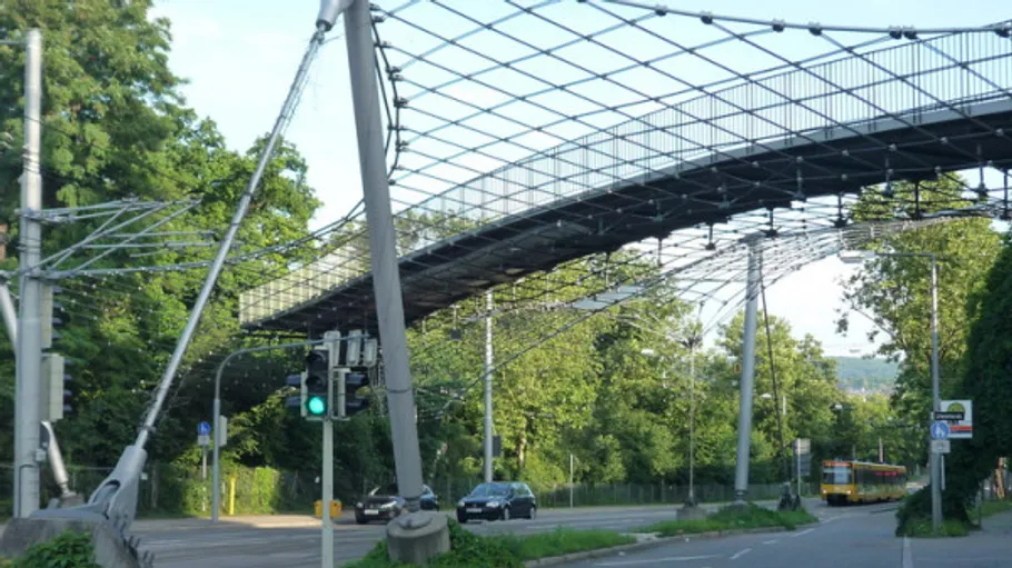 Moderne Fußgängerbrücke über Straße mit Autos.