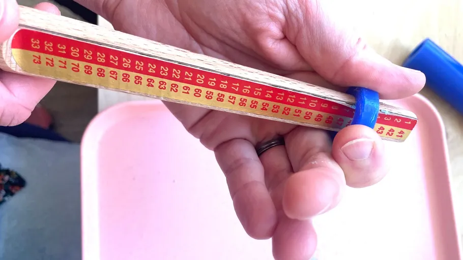 Hände halten nummerierten Stab mit Gummiring.