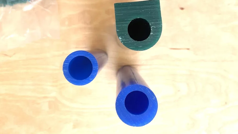Drei Plastikröhren auf einer Holzoberfläche.