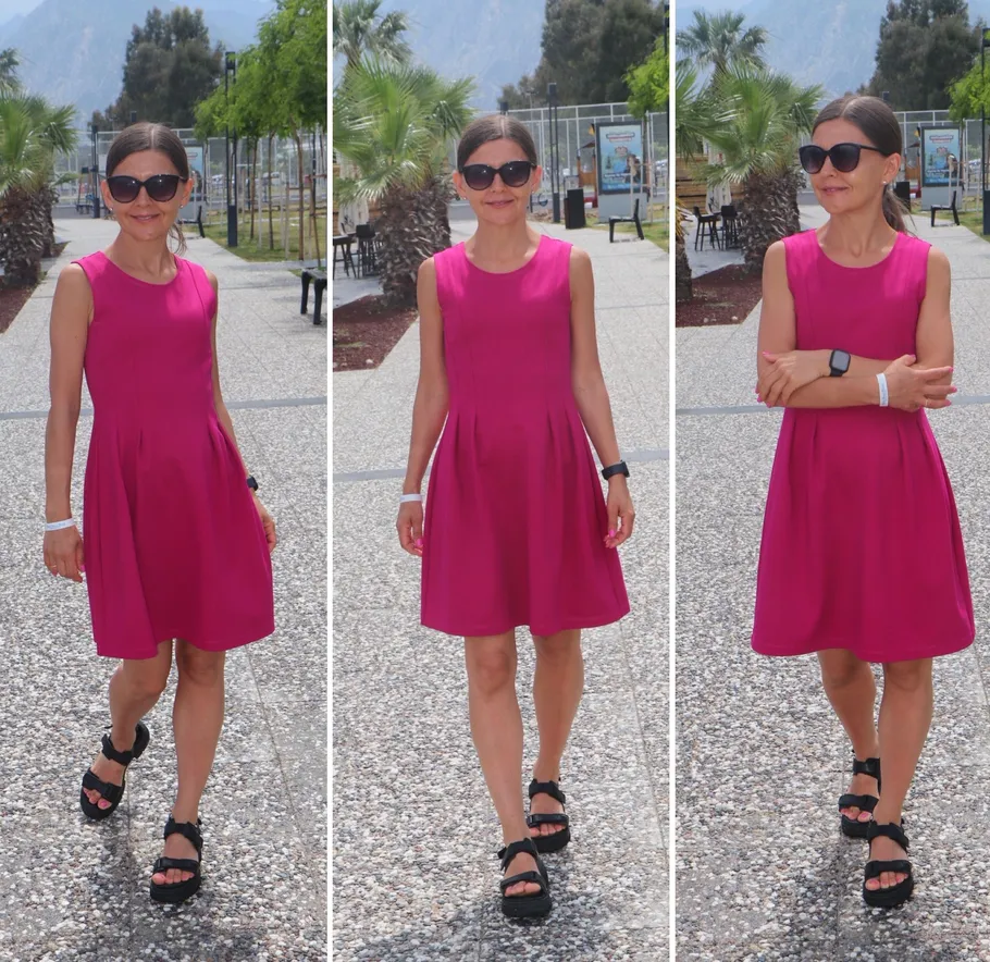 Woman in pink dress walking outdoors sunny day.