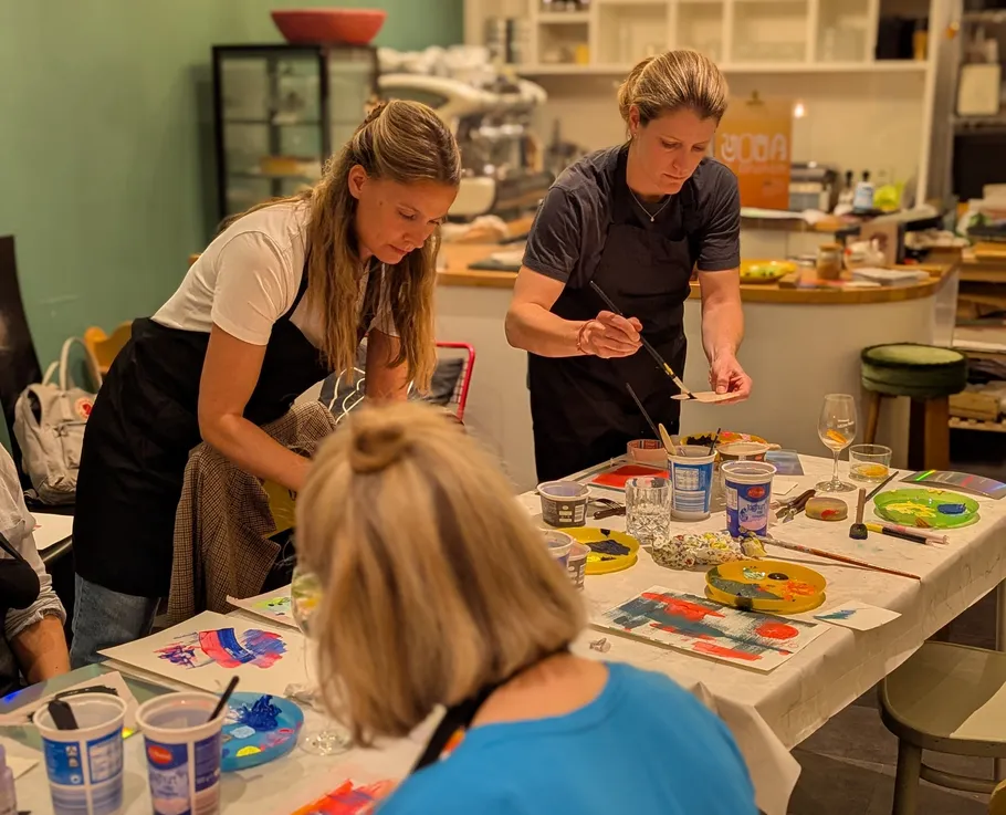 People painting at a workshop in a kitchen.