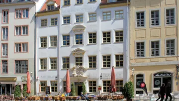 Historic building with café and outdoor seating.