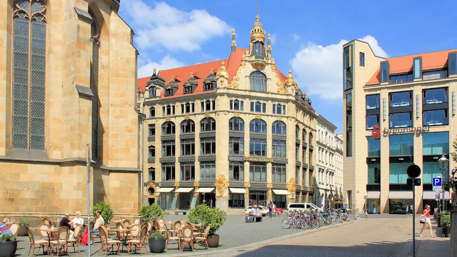 Outdoor cafe near historic and modern buildings.